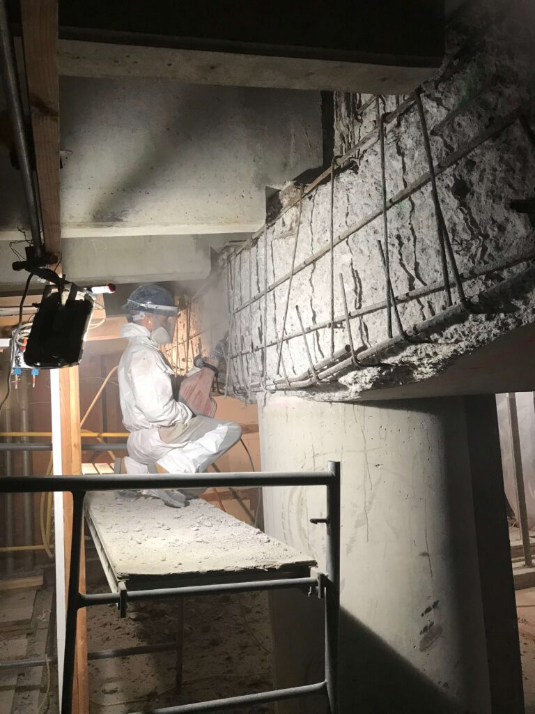 Construction worker laboring on a concrete structure at a job site