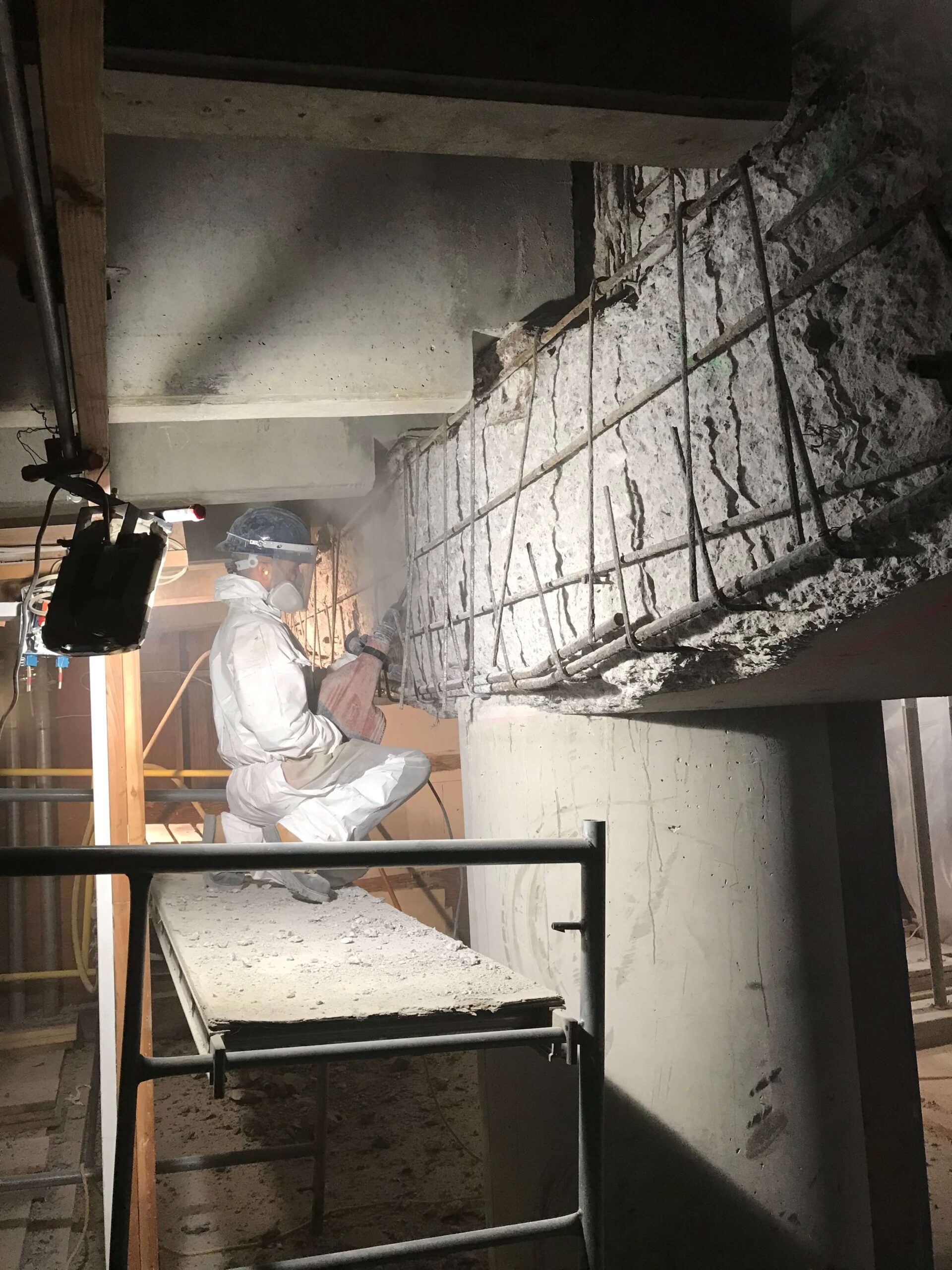 Construction worker laboring on a concrete structure at a job site