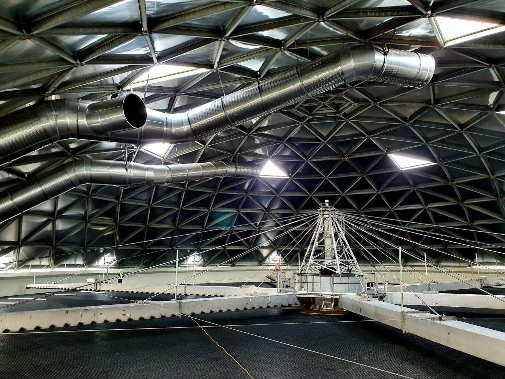 A complex metal framework with pipes and a high ceiling